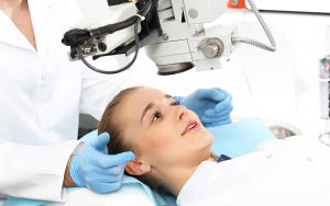 A woman getting her ears cleaned by an optometrist.